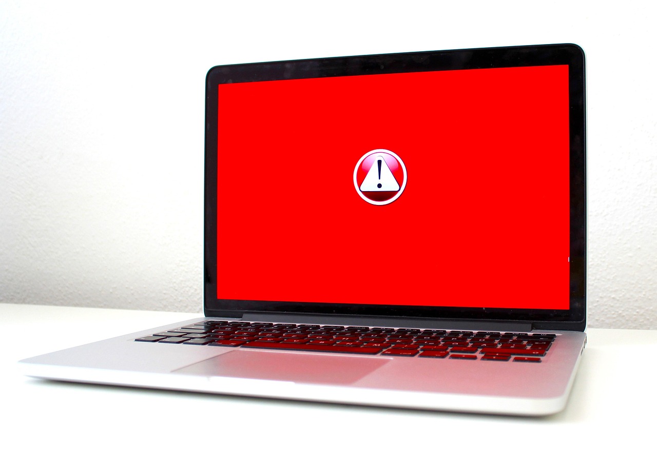 Laptop z czerwonym ostrzeżeniem