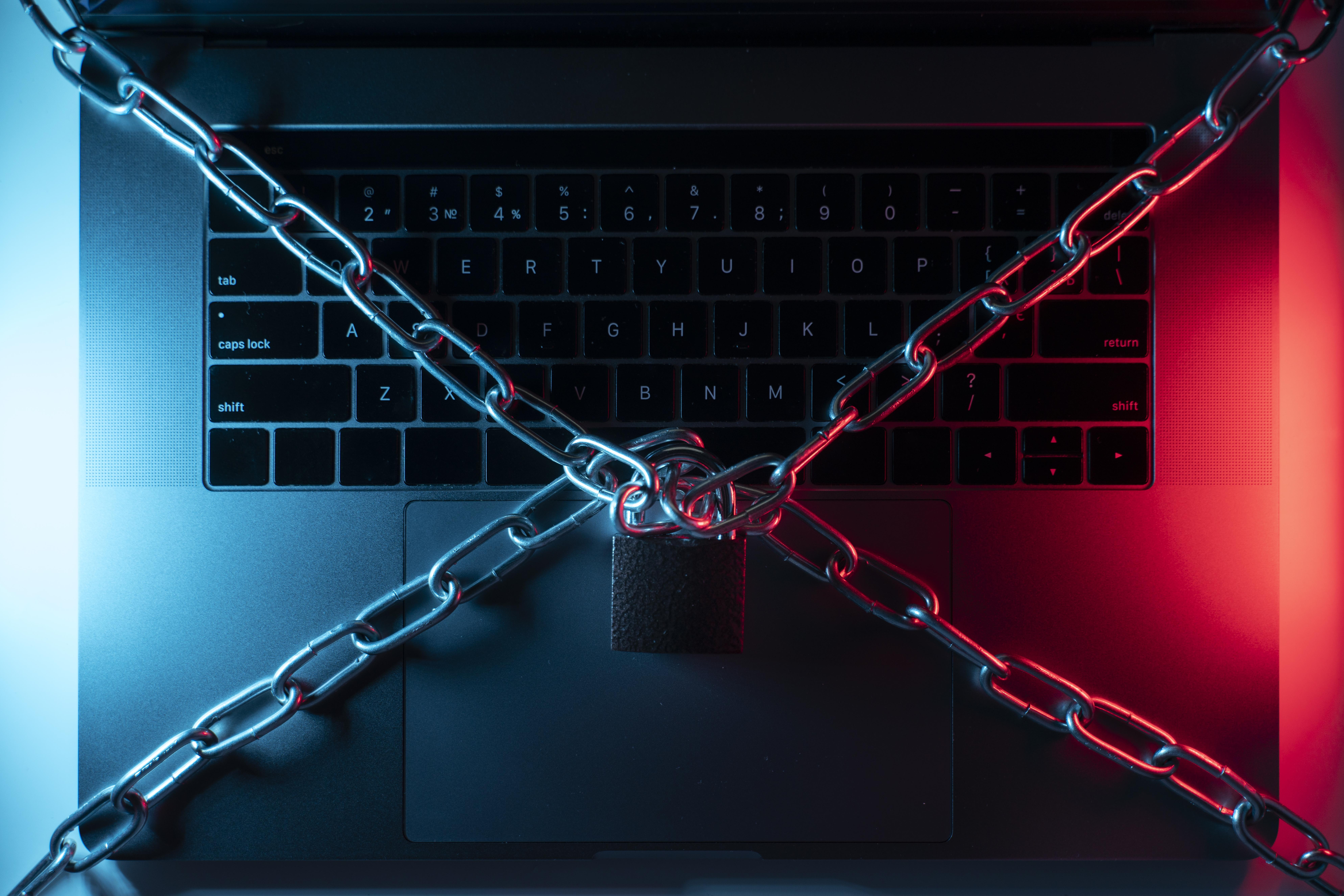 Laptop z łańcuchami i kłódką na środku klawiatury